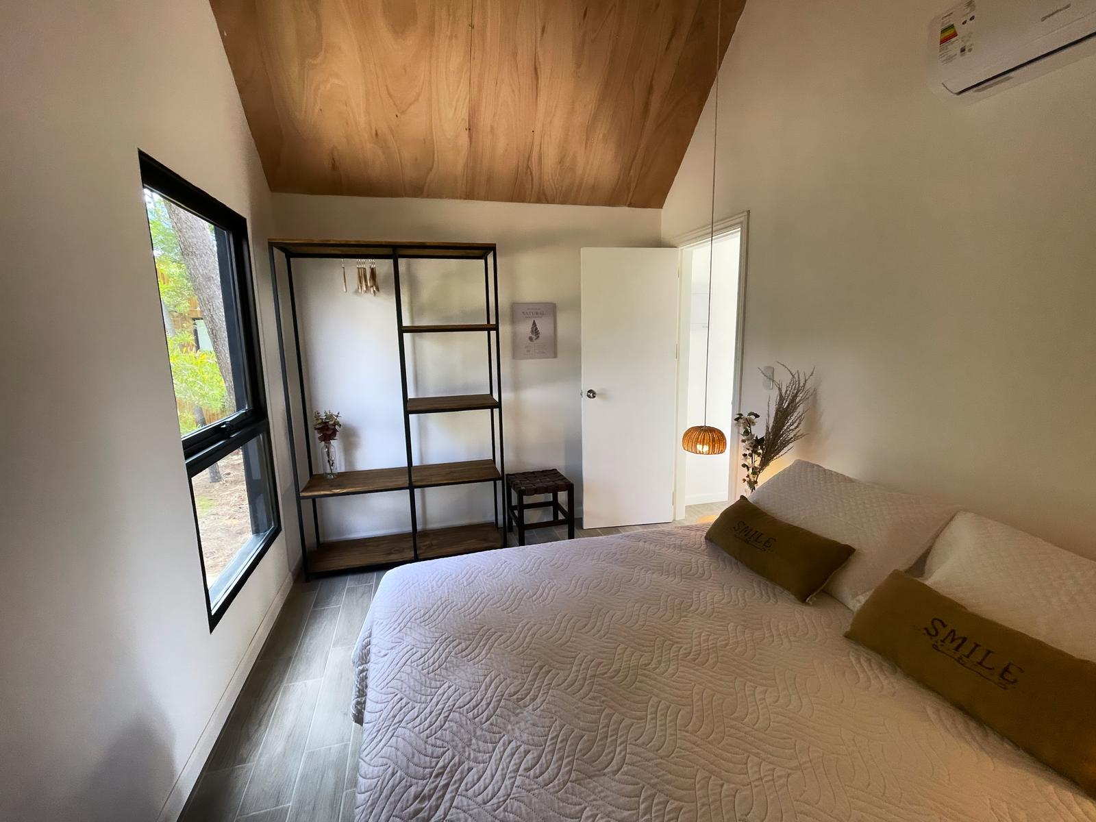 Dormitorio con lana cruda, luz cálida y ventana al bosque