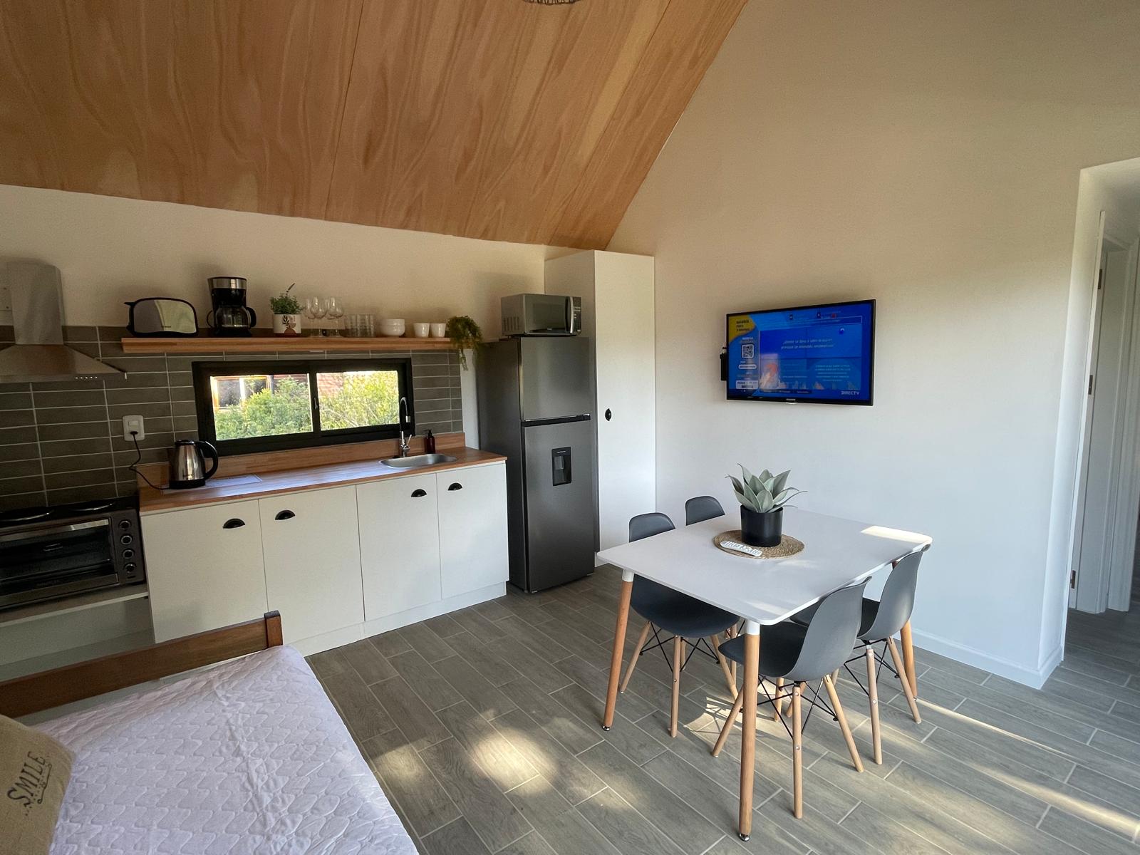 Cocina completa con techo de madera y ventana al jardín
