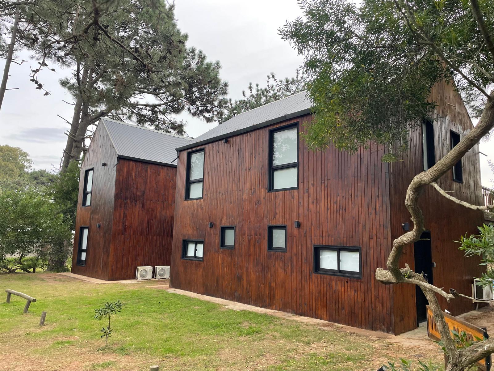 Las dos fachadas de madera de Villa Mora en un día de bosque